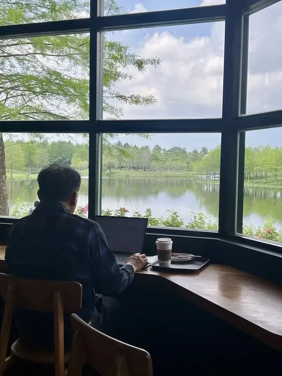 Laptop user at lagoon-view window seat Starbucks Promisedland — Taiwan Insider